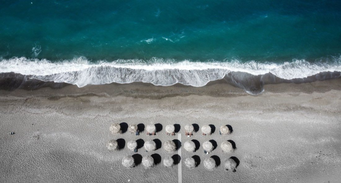 Spiaggia con ombrelloni e il mare al sole